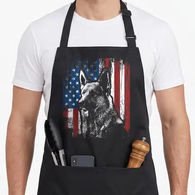 German american flag apron - Distressed grey German Shepherd head over red white and blue flag pattern — shown on a black cotton canvas apron against a white background