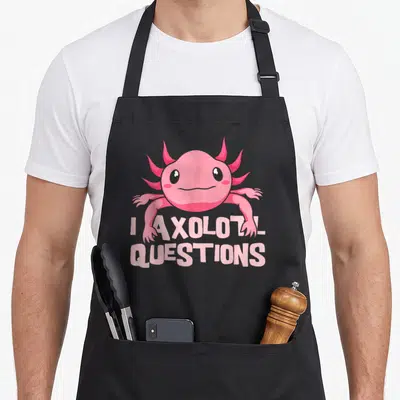 Amphibian mexican apron - Pink cartoon axolotl above two lines of text reading I AXOLOTL QUESTIONS — shown on a black cotton canvas apron against a white background