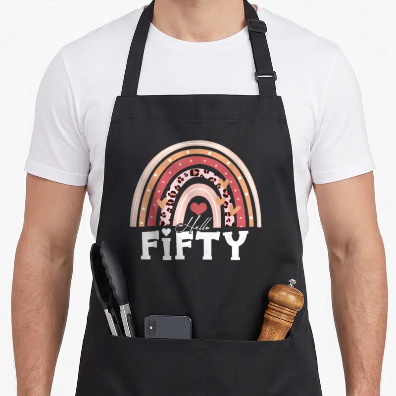 Boho leopard apron - Retro rainbow with leopard print band and Hello FIFTY text — shown on a black cotton canvas apron against a white background