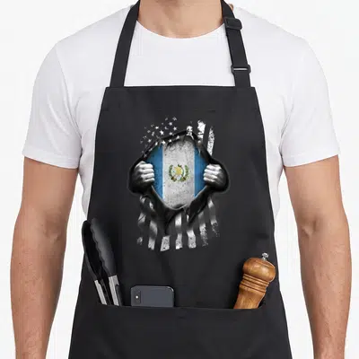 Guatemala national american flag apron - Hands ripping fabric to reveal Guatemalan flag with white stars in blue — shown on a black cotton canvas apron against a white background