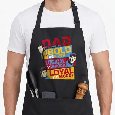 Original thriller apron - Retro Star Trek style graphic with portraits and text praising dad qualities — shown on a black cotton canvas apron against a white background
