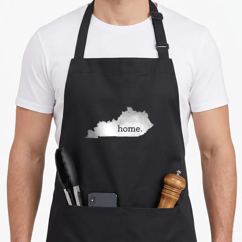 Cute kentucky boy apron - Silver glitter Kentucky state silhouette with home printed inside on white background — shown on a black cotton canvas apron against a white background