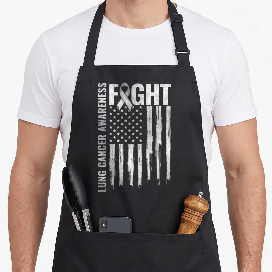 Awareness fight ribbon apron - White distressed FIGHT text with ribbon and US flag, vertical LUNG CANCER AWARENESS text — shown on a black cotton canvas apron against a white background