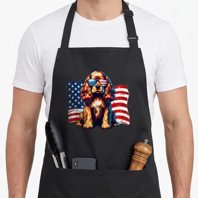 Flag cocker spaniel apron - Realistic Cocker Spaniel wearing sunglasses in front of a waving red white and blue — shown on a black cotton canvas apron against a white background