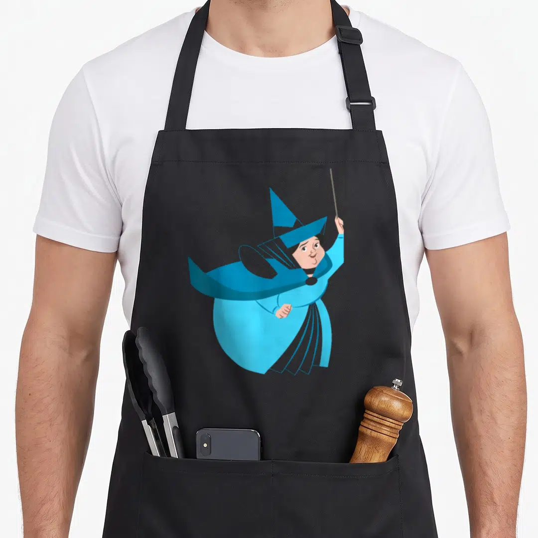 Merryweather beauty apron - Cartoon blue witch holding wand aloft in peach and brown accents — shown on a black cotton canvas apron against a white background