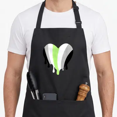 Funny lime green apron - Heart shape with vertical black grey white and lime green stripes dripping downwards — shown on a black cotton canvas apron against a white background
