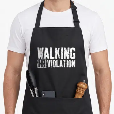 Employee walking apron - White distressed WALKING HR VIOLATION text on black background — shown on a black cotton canvas apron against a white background