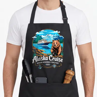 Alaskan friends cooking apron - Retro bear and ship scene with Alaska Cruise text and 2025 date — shown on a black cotton canvas apron against a white background