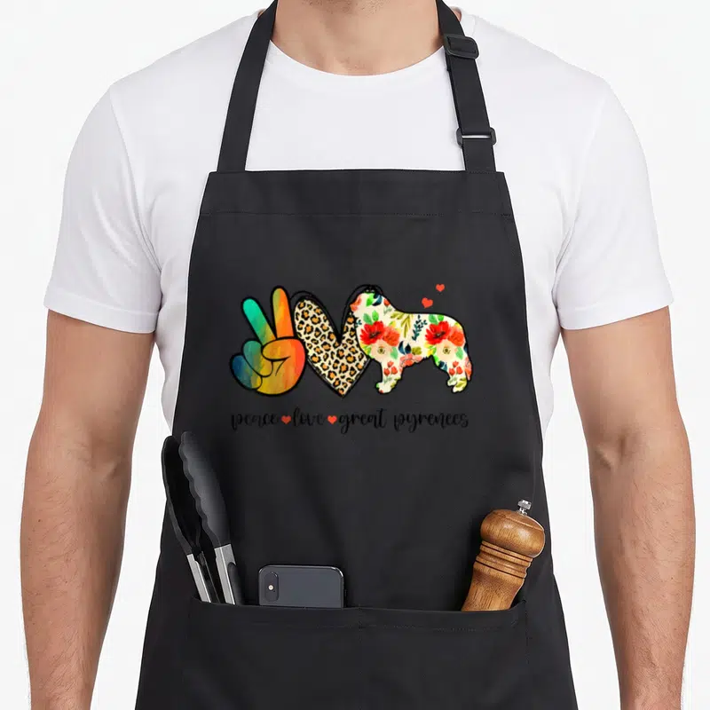 Peace pyrenee dog apron - Rainbow peace hand, leopard heart, floral dog silhouette, and script text with small red — shown on a black cotton canvas apron against a white background