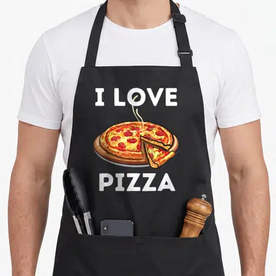 Foodie pizza apron - Cartoon pepperoni pizza on wooden board with slice pulled out and white text — shown on a black cotton canvas apron against a white background