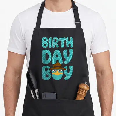 Phineas custom face apron - Cartoon duck head with brown hat inside teal striped BIRTH DAY BOY text — shown on a black cotton canvas apron against a white background
