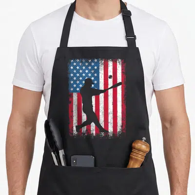 Baseball 4th of july apron - Grey batter silhouette swinging bat over distressed red white and blue USA flag — shown on a black cotton canvas apron against a white background