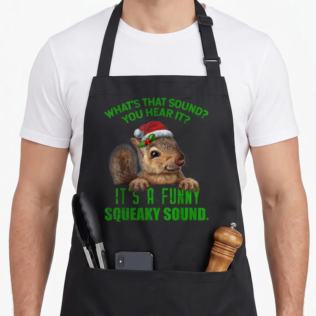 Sound christmas apron - Realistic squirrel in red Santa hat with green text asking about a squeaky sound — shown on a black cotton canvas apron against a white background