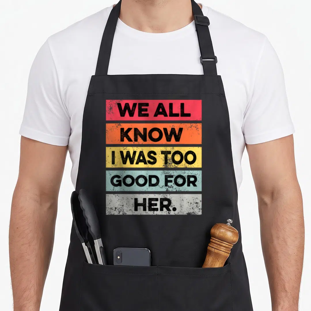 Funny divorced divorce party apron - Stacked colorful text blocks reading WE ALL KNOW I WAS TOO GOOD FOR HER in bold — shown on a black cotton canvas apron against a white background