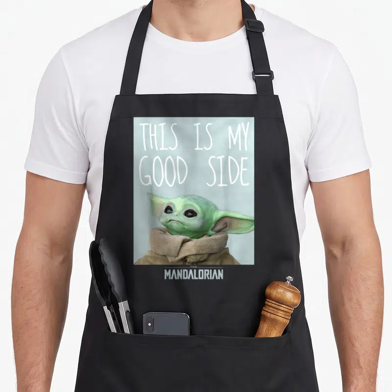 Cute english class apron - Grogu photo with THIS IS MY GOOD SIDE text and THE MANDALORIAN logo below — shown on a black cotton canvas apron against a white background