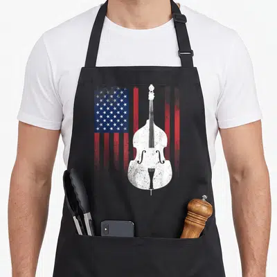 Double american flag apron - White double bass silhouette on distressed red white and blue US flag background — shown on a black cotton canvas apron against a white background