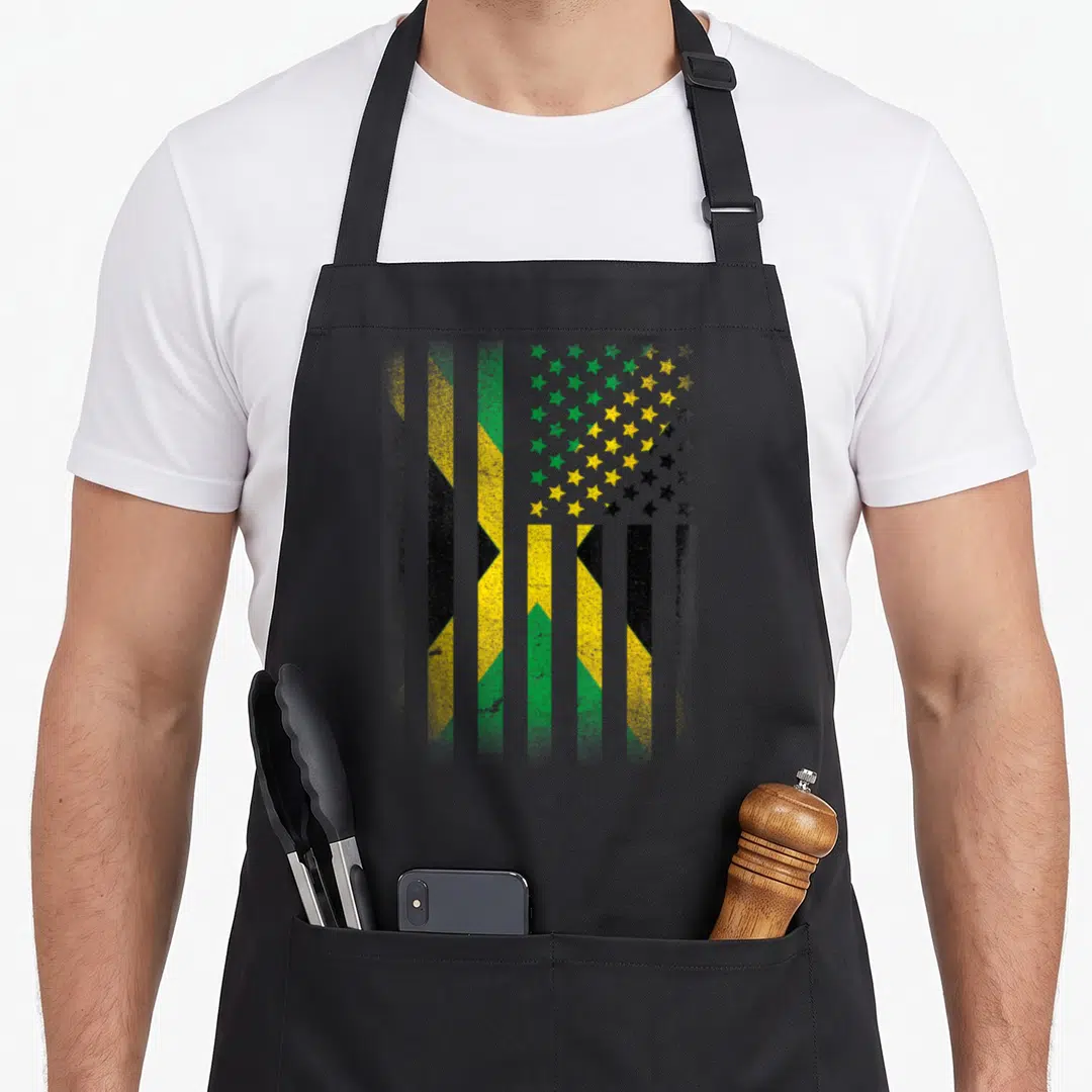 Jamaican american flag apron - Vertical green yellow black striped flag with distressed star field pattern — shown on a black cotton canvas apron against a white background