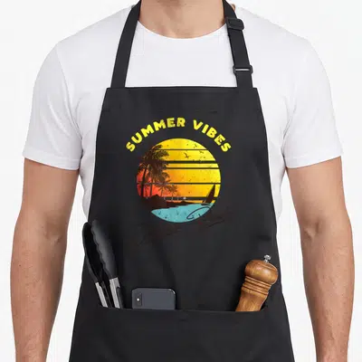 Daytona beach summer aprons - Retro sunset with palms birds sailboat and SUMMER VIBES Daytona Beach text — shown on a black cotton canvas apron against a white background