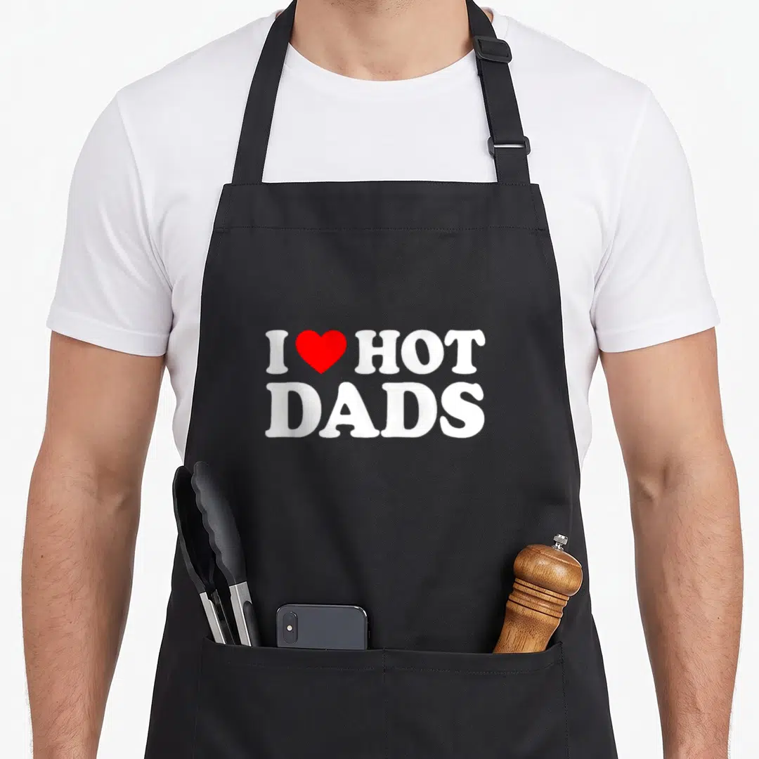 Funny love hot apron - White I HOT DADS text with red heart symbol centered below — shown on a black cotton canvas apron against a white background