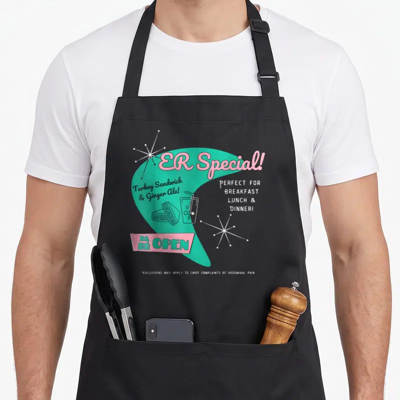 Parody nurse apron - Retro teal and pink ER Special diner menu with sandwich and ginger ale art — shown on a black cotton canvas apron against a white background