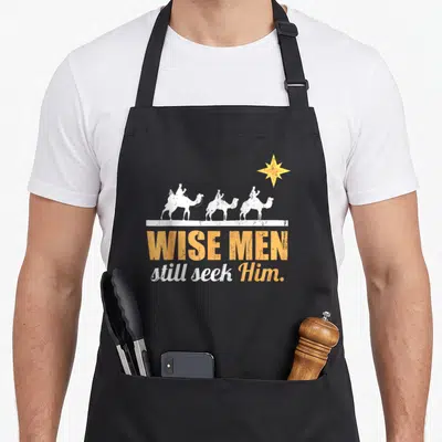 Jesus lord christian apron - Three white camels facing right above yellow and white text reading Wise Men still seek Him — shown on a black cotton canvas apron against a white background