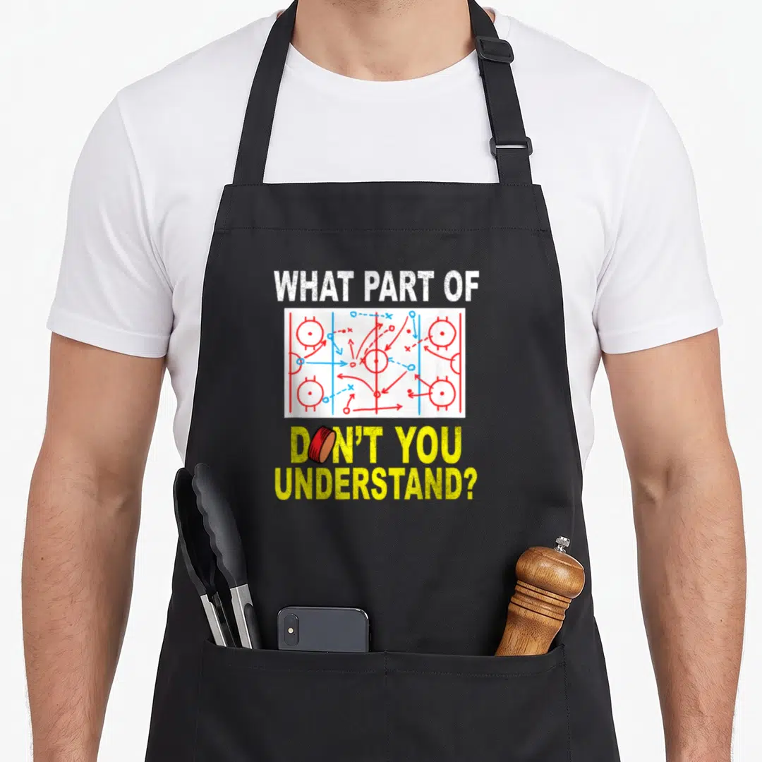 Ice parts of an apron - Hockey play diagram with puck replacing O in sarcastic text — shown on a black cotton canvas apron against a white background