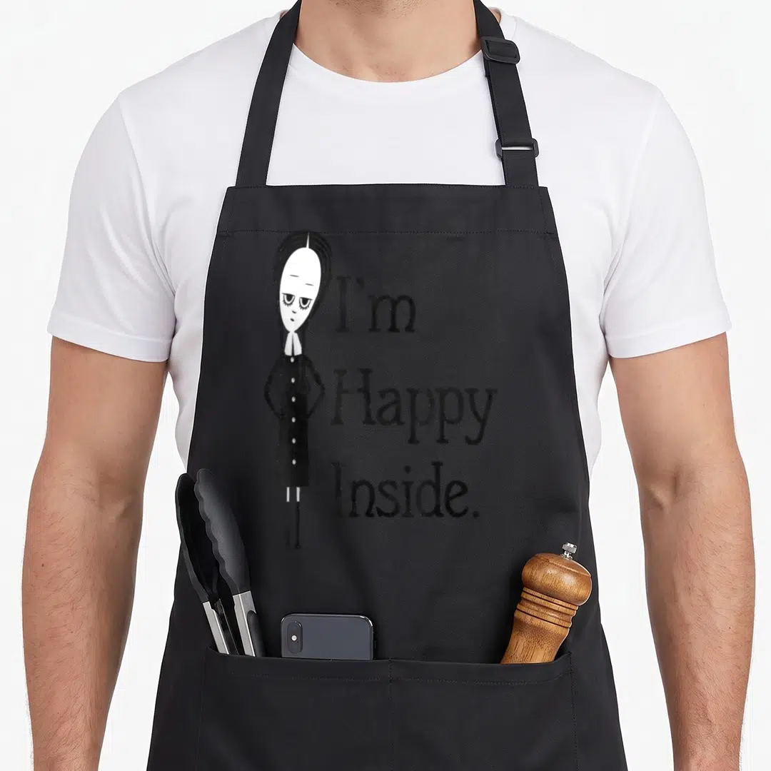 Inside family aprons - Cartoon girl standing next to stacked text I'm Happy Inside in black and white — shown on a black cotton canvas apron against a white background