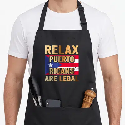 Relax ricotta apron - Retro Puerto Rican flag with gold text Relax Puerto Ricans Are Legal — shown on a black cotton canvas apron against a white background