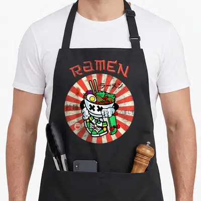 Skater anime apron - Cartoon ramen bowl with X eyes holding skateboard over sneakers with multilingual text — shown on a black cotton canvas apron against a white background