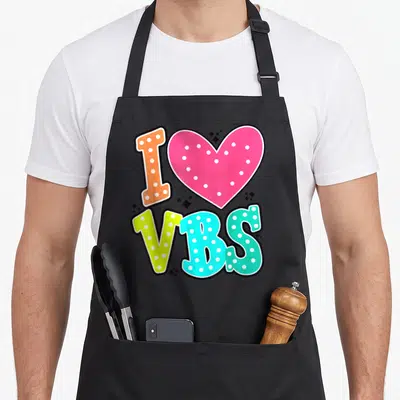 Vbs vacation christian apron - Cartoon I Love VBS design with pink heart and orange, yellow, blue text with white dots — shown on a black cotton canvas apron against a white background