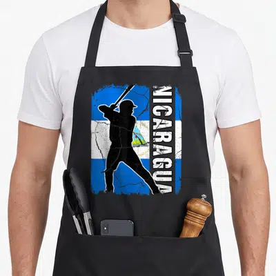 Nicaraguan baseball apron - Black batter silhouette on distressed blue white flag with vertical NICARAGUA text — shown on a black cotton canvas apron against a white background