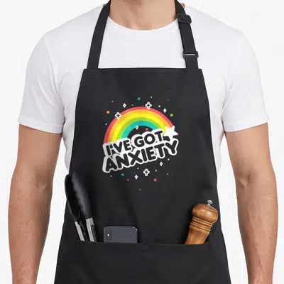 Lookhuman nerd apron - Cartoon rainbow in white red yellow green blue over stacked I've Got Anxiety text surrounded — shown on a black cotton canvas apron against a white background
