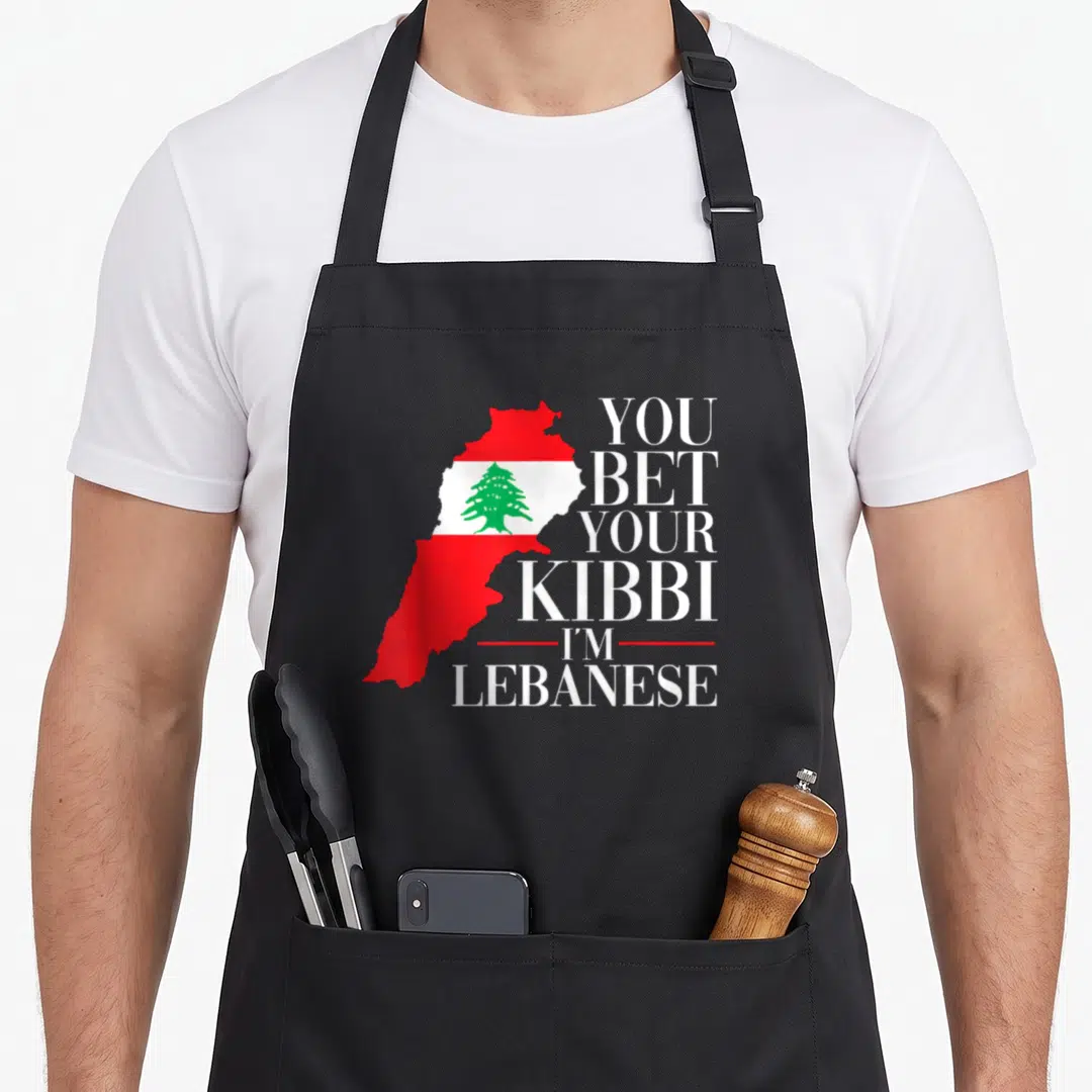 Lebanon lebanese apron - Map of Lebanon in red white green with stacked text YOU BET YOUR KIBBI I'M LEBANESE — shown on a black cotton canvas apron against a white background