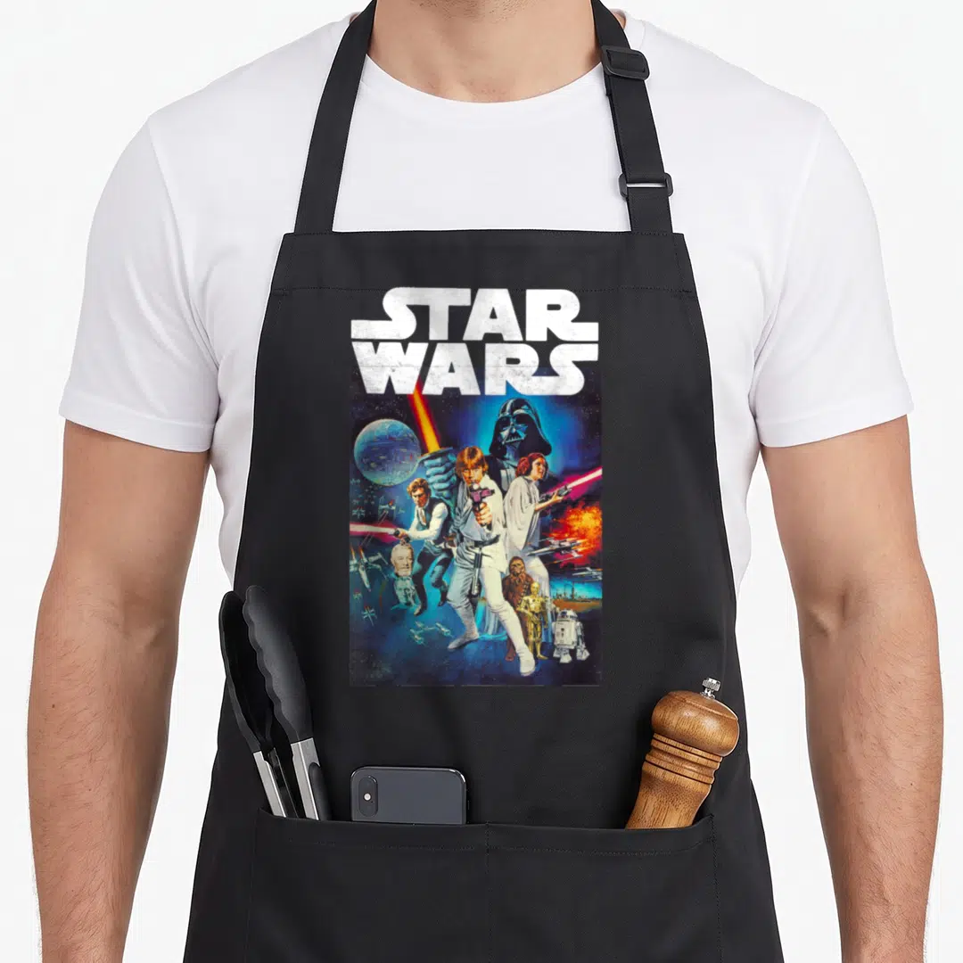 Cast star war apron - STAR WARS text above Luke Skywalker and Darth Vader photo montage in blue and red — shown on a black cotton canvas apron against a white background