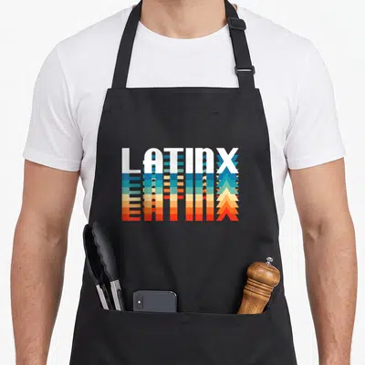 Latinx spanish aprons - LATINX text in white with blue, teal, yellow, orange, and red stripe reflection below — shown on a black cotton canvas apron against a white background