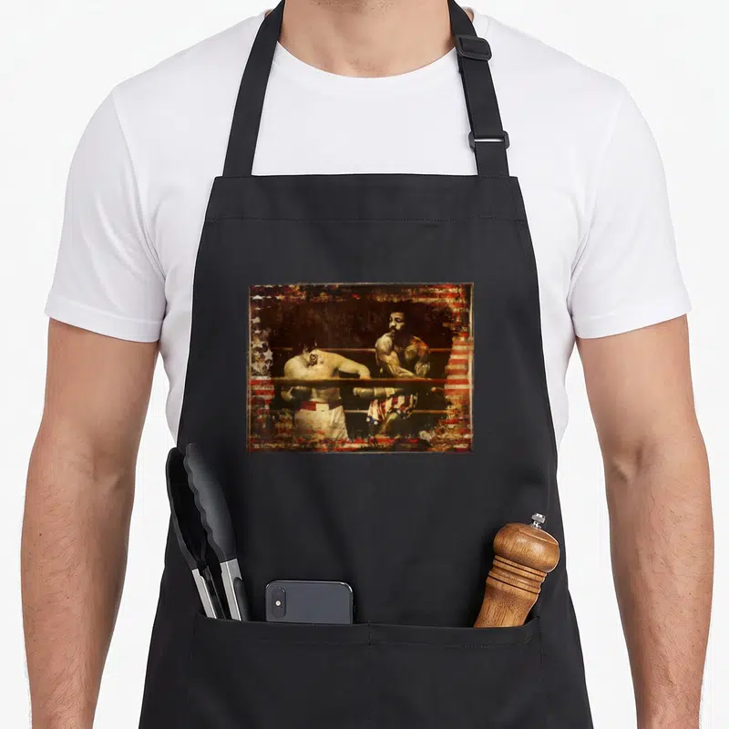 Upper apollo apron - Two boxers leaning on ring ropes with distressed flag pattern overlay in red white and blue — shown on a black cotton canvas apron against a white background