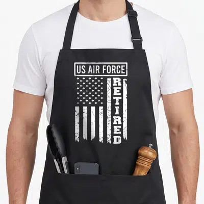 Force american flag apron - US AIR FORCE box and vertical RETIRED text on distressed white flag stripes — shown on a black cotton canvas apron against a white background
