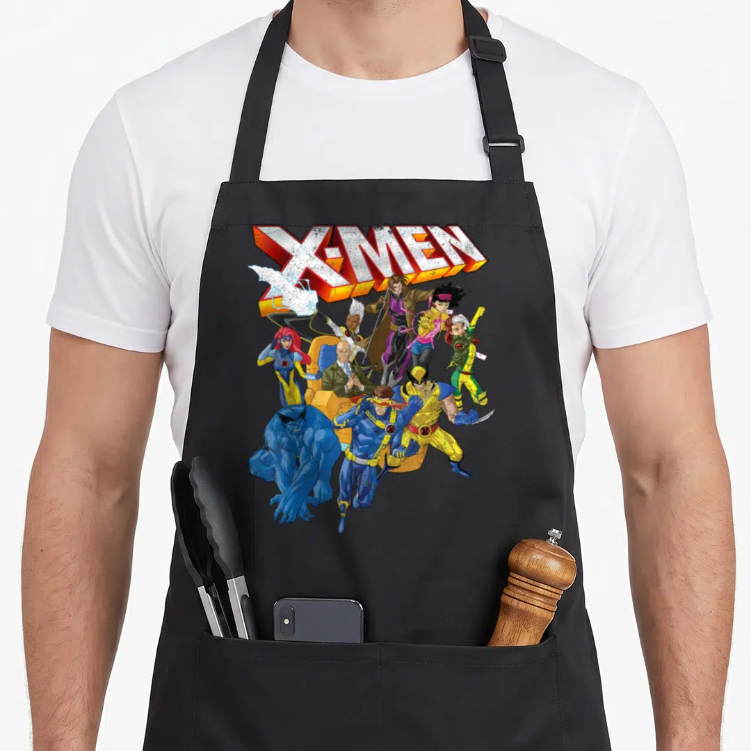 Shot x apron - X-MEN logo above dynamic group of comic characters in yellow blue red white cartoon style — shown on a black cotton canvas apron against a white background