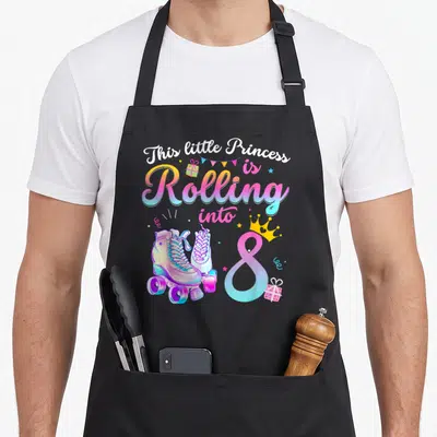 Roller birthday apron - Roller skates and number 8 with crown and This little Princess is Rolling into 8 text — shown on a black cotton canvas apron against a white background