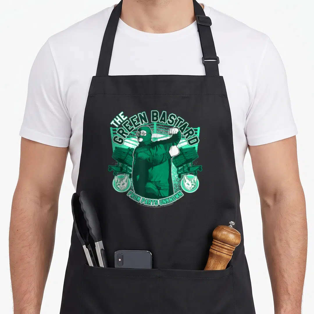 Wrestler trailer apron - Green masked wrestler with shopping carts and cat heads under arched text — shown on a black cotton canvas apron against a white background
