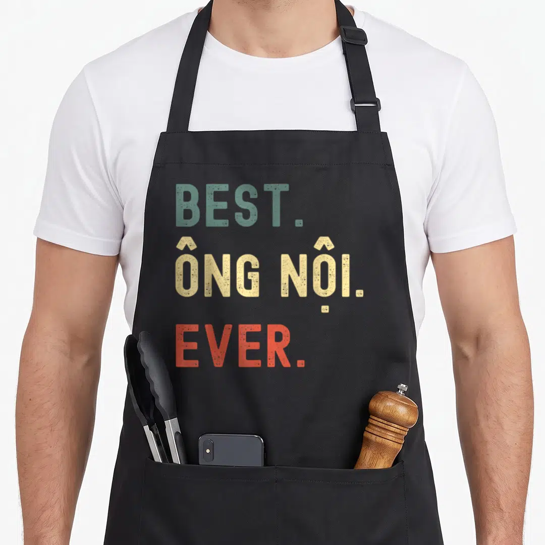 Ong grandpa apron - Distressed stacked text reading BEST. ÔNG NỘI. EVER. in teal, beige, and orange-red — shown on a black cotton canvas apron against a white background
