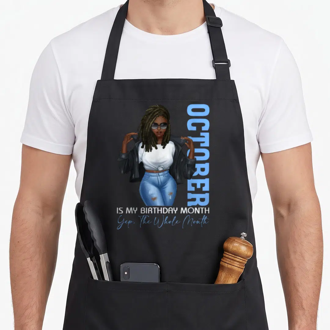 Month october birthday apron - Woman in blue jeans holding black jacket beside vertical OCTOBER text and stacked — shown on a black cotton canvas apron against a white background