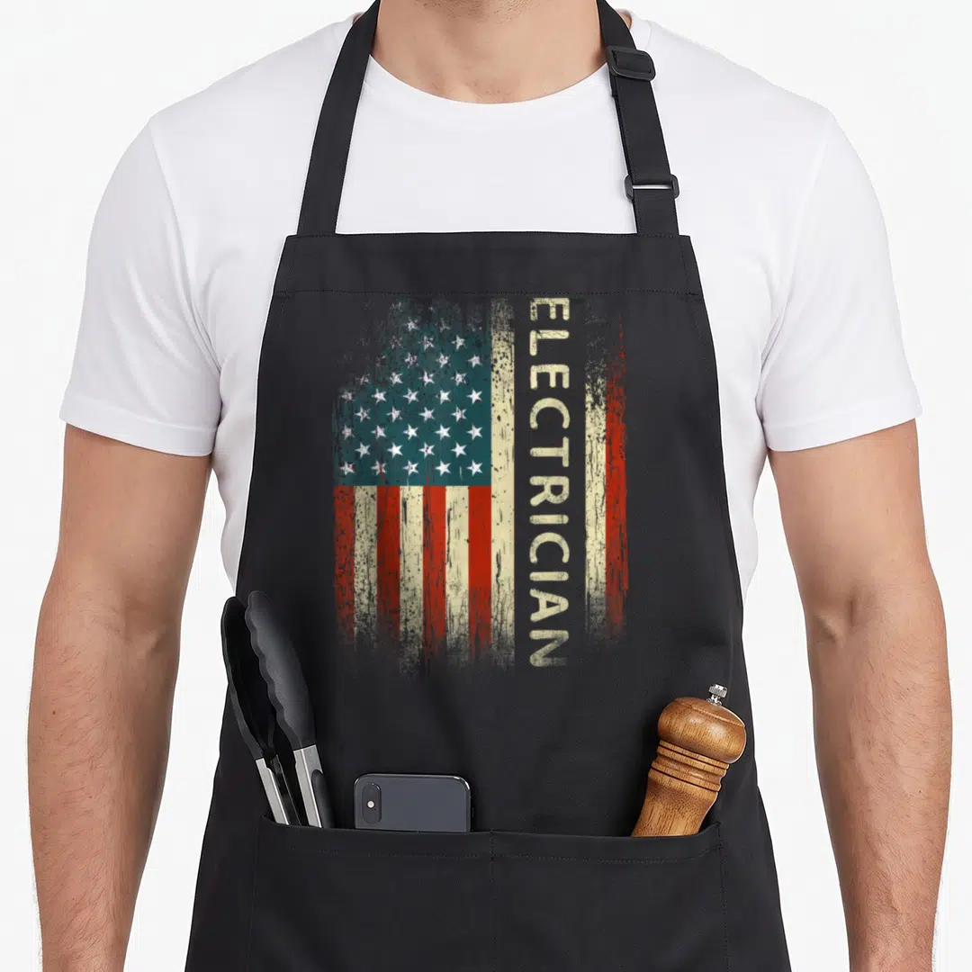 Electrician american flag apron - Distressed USA flag with vertical beige ELECTRICIAN text on right side — shown on a black cotton canvas apron against a white background