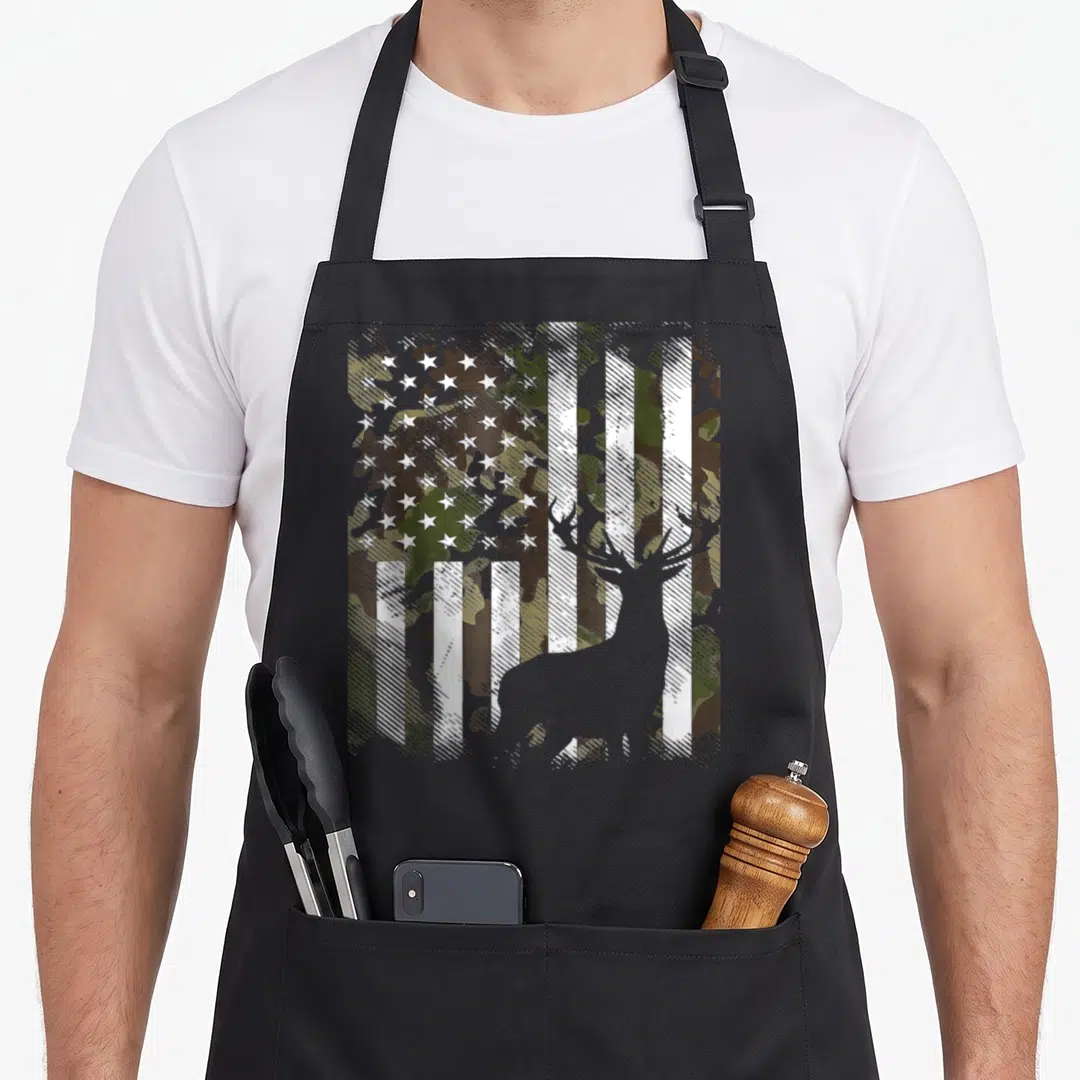 Elk camo apron - Grey deer silhouette overlaid on distressed green brown tan camo US flag pattern — shown on a black cotton canvas apron against a white background