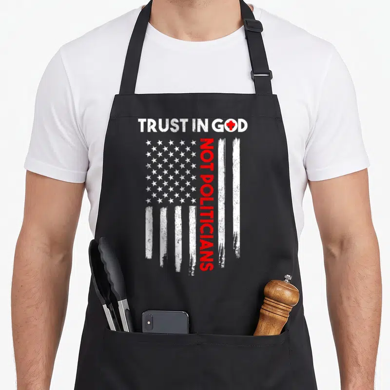 Politician american flag apron - Distressed white stars and stripes with vertical red text and a red cross replacing — shown on a black cotton canvas apron against a white background