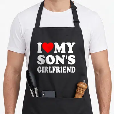 Son gathering apron - Red heart between I and MY above SON'S GIRLFRIEND in white block letters — shown on a black cotton canvas apron against a white background