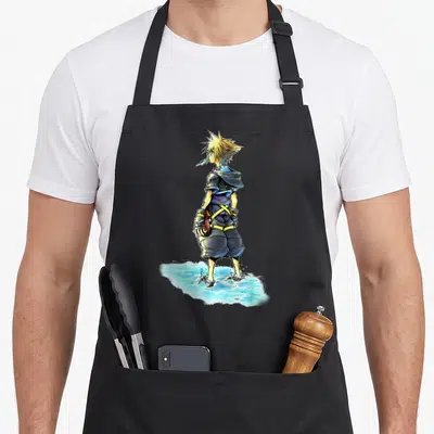 Sora ice cream apron - Cartoon blonde man in blue clothes standing in light blue water holding a blue treat — shown on a black cotton canvas apron against a white background