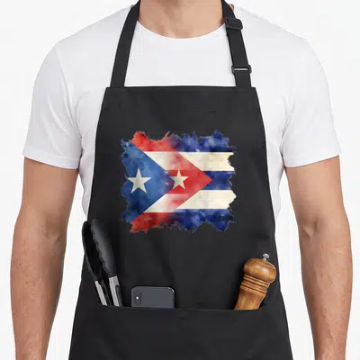 Puerto cuban apron - Watercolor style combined flag design with red white and blue splattered edges and stars — shown on a black cotton canvas apron against a white background