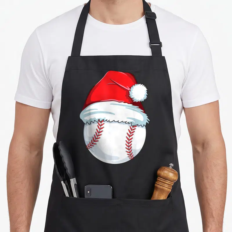 Xmas santa aprons - Cartoon white baseball wearing a red Santa hat with red stitching — shown on a black cotton canvas apron against a white background