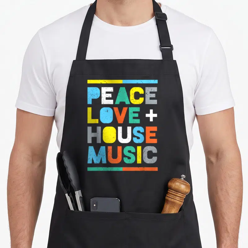 Peace edm apron - Stacked colorful text PEACE LOVE + HOUSE MUSIC with horizontal bars — shown on a black cotton canvas apron against a white background